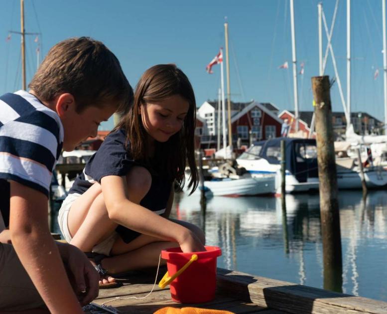 To børn fanger krabber på krabbebroen på Juelsminde Havn