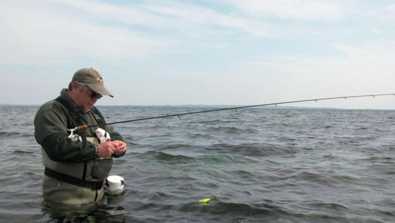 Mand sætter madding på krogen på fisketur